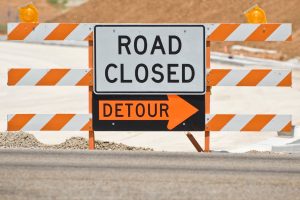 road closed and detour signage on road